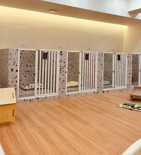 A row of dog rooms with white gates in our boarding area